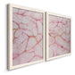 Angled view of a set of two white barnwood framed canvas prints featuring two soft stone-inspired abstracts featuring pink marble veining with fine gold lines.