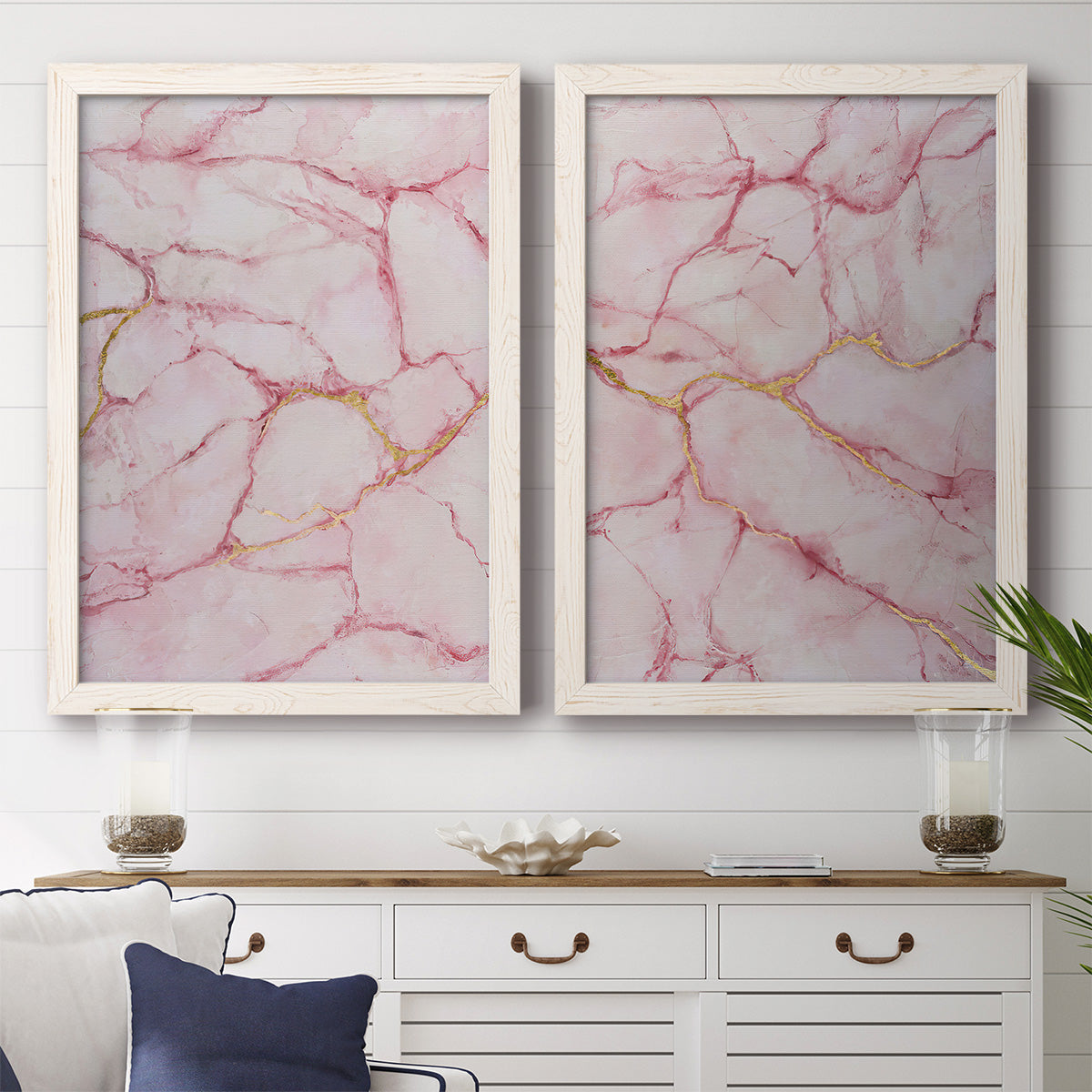 Set of two white barnwood framed canvas prints depicting a coordinated art pair of pink marble veining with fine gold lines rendered as soft stone-inspired abstracts above a dining room sideboard.