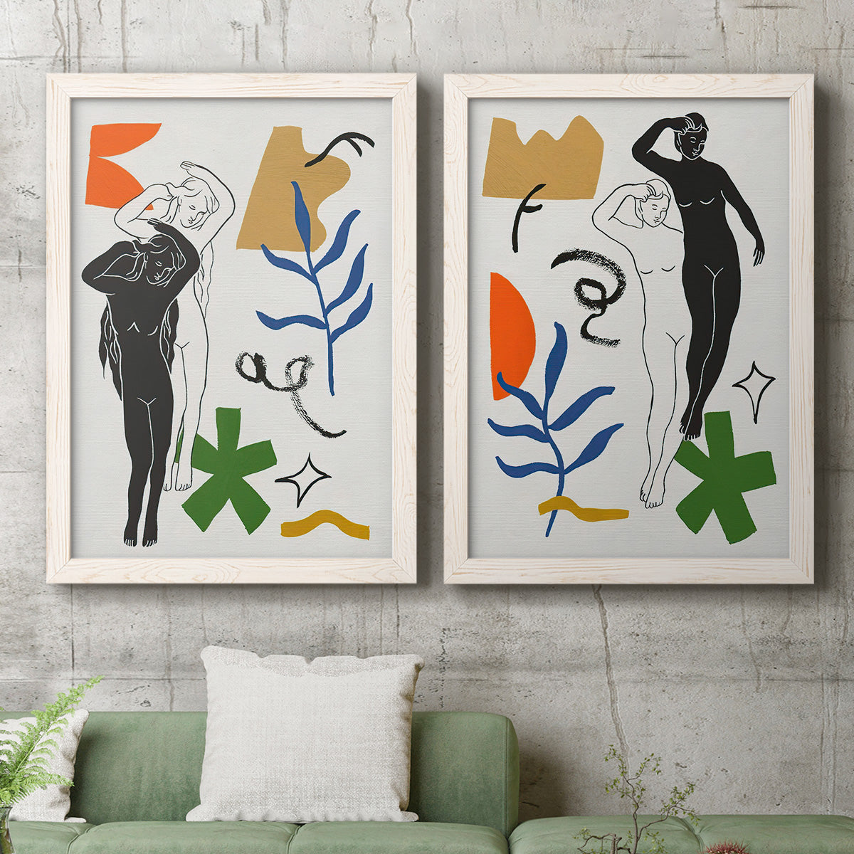 Set of two white barnwood framed canvas prints depicting stylized female figures surrounded by blue leaves green starbursts orange forms and gestural marks above a sofa in a modern living room.