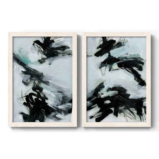 Set of two white barnwood framed canvas prints featuring two gestural ocean-inspired abstracts featuring sweeping black brushstrokes over pale blue-gray fields.