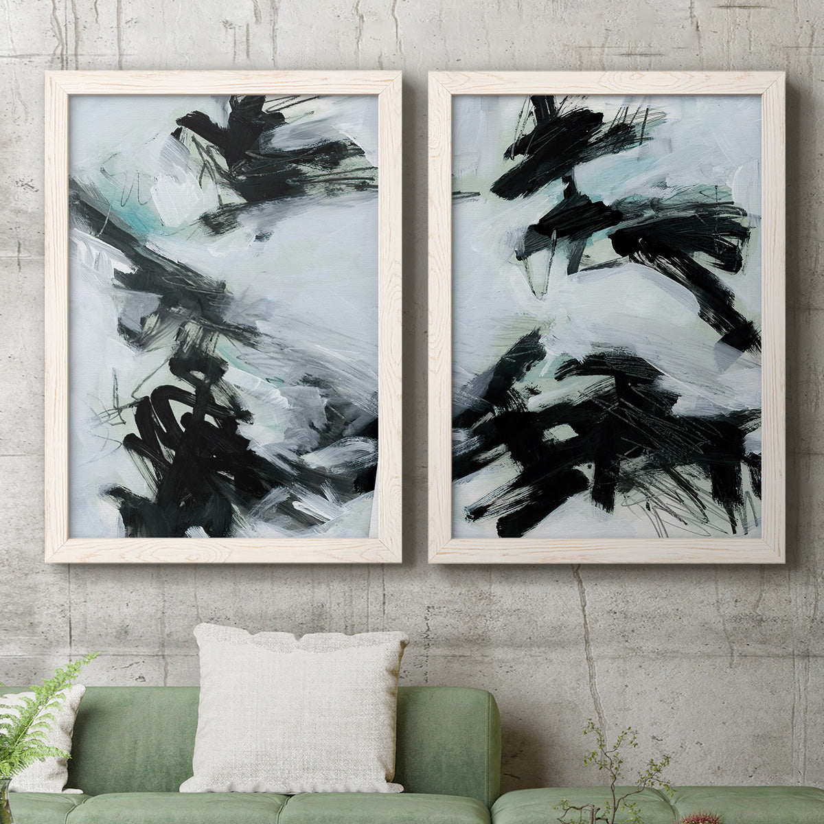 Set of two white barnwood framed canvas prints depicting a coordinated art pair of sweeping black brushstrokes over pale blue-gray fields rendered as gestural ocean-inspired abstracts above a sofa in a modern living room.