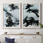 Set of two white barnwood framed canvas prints depicting a coordinated art pair of sweeping black brushstrokes over pale blue-gray fields rendered as gestural ocean-inspired abstracts above a dining room sideboard.