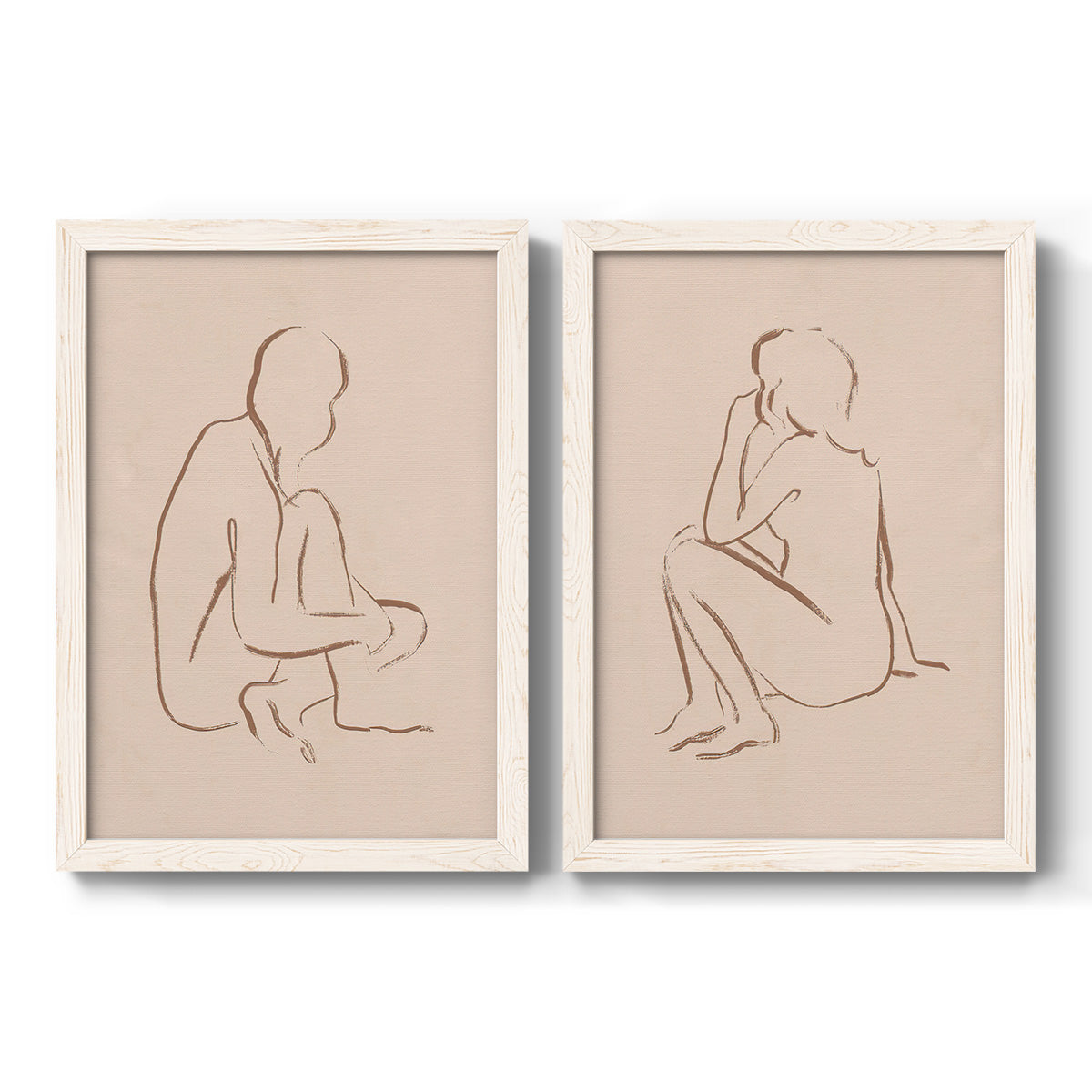 Set of two white barnwood framed canvas prints featuring two minimalist figurative sketches featuring seated female figures drawn with single flowing lines.