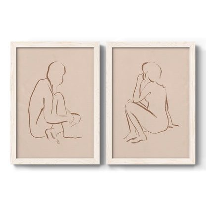 Set of two white barnwood framed canvas prints featuring two minimalist figurative sketches featuring seated female figures drawn with single flowing lines.