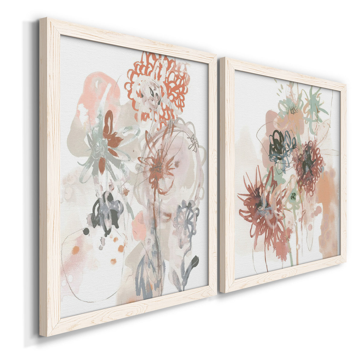 Angled view of a set of two white barnwood framed canvas prints featuring two abstract watercolor botanicals featuring loose blush gray and coral floral gestures.