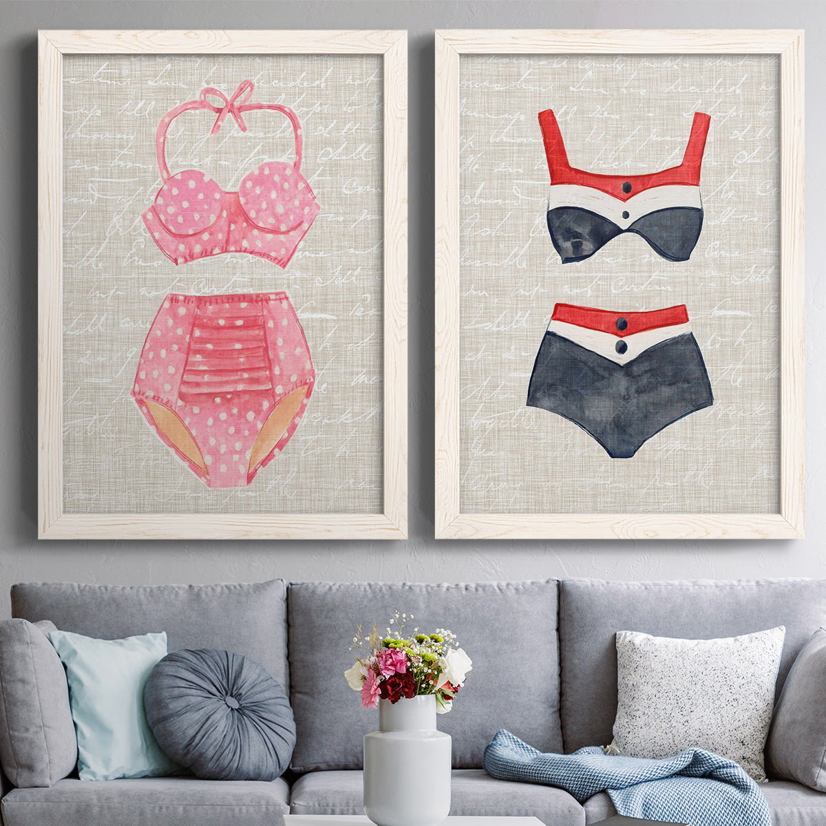 Set of two white barnwood framed canvas prints depicting paired vintage fashion illustrations with striped and patterned bathing suits in red pink navy and white above a sofa in a contemporary living room.