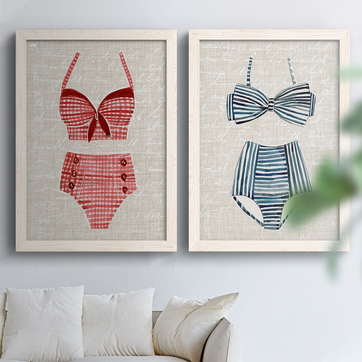 Set of two white barnwood framed canvas prints depicting striped and patterned bathing suits in red pink navy and white arranged across two complementary compositions above a sofa in a bright living space.