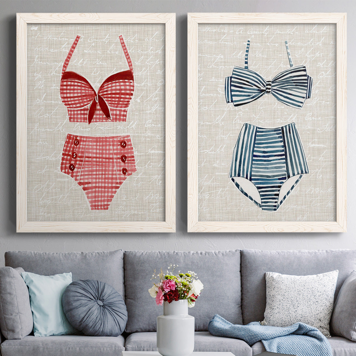 Set of two white barnwood framed canvas prints depicting paired vintage fashion illustrations with striped and patterned bathing suits in red pink navy and white above a sofa in a contemporary living room.