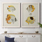 Set of two white barnwood framed canvas prints depicting a coordinated art pair of groups of vintage tropical fish rendered as natural-history fish illustrations above a dining room sideboard.