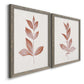 Angled view of a set of two gray barnwood framed canvas prints featuring two minimalist botanical prints featuring single rust-red leafy stems.