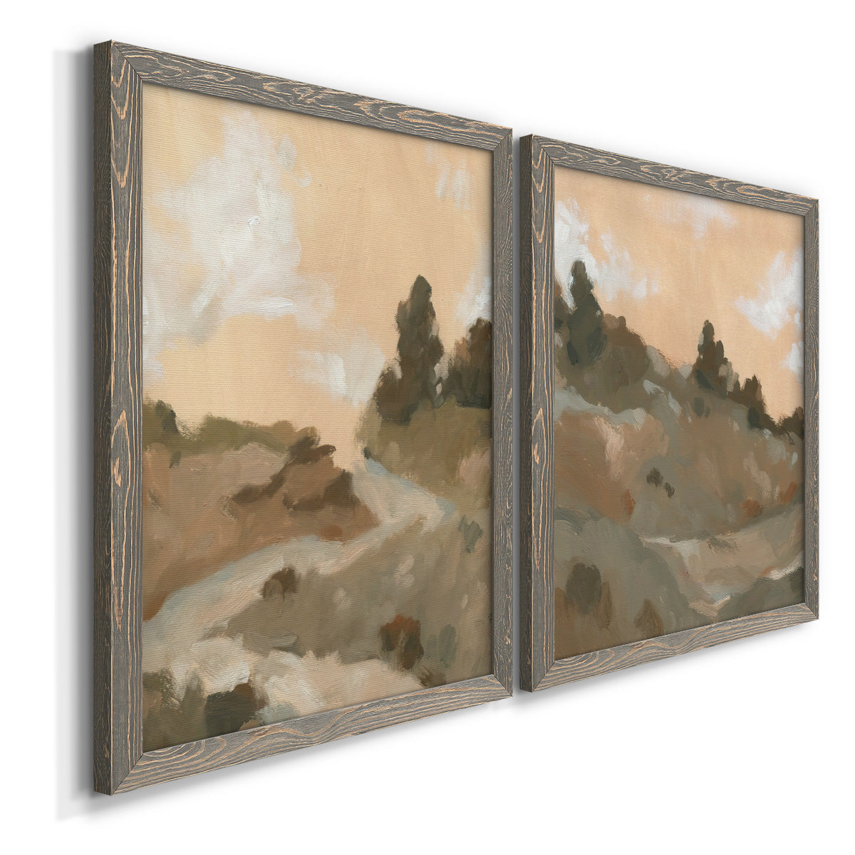 Angled view of a set of two gray barnwood framed canvas prints featuring two minimalist watercolor landscapes featuring misty brown hills and winding mountain paths.