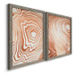 Angled view of a set of two gray barnwood framed canvas prints featuring two minimalist marbled pattern abstracts featuring concentric wood-grain rings and rippling contour lines.
