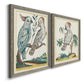 Angled view of a set of two gray barnwood framed canvas prints featuring two atmospheric abstract paintings featuring misty blue gray and violet marks hovering across pale grounds.