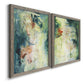 Angled view of a set of two gray barnwood framed canvas prints featuring two nature-inspired mixed-media abstracts featuring layered blue green cream and charcoal textures.