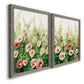 Angled view of a set of two gray barnwood framed canvas prints featuring two luminous impressionistic floral paintings featuring a field of pink coral and white flowers.