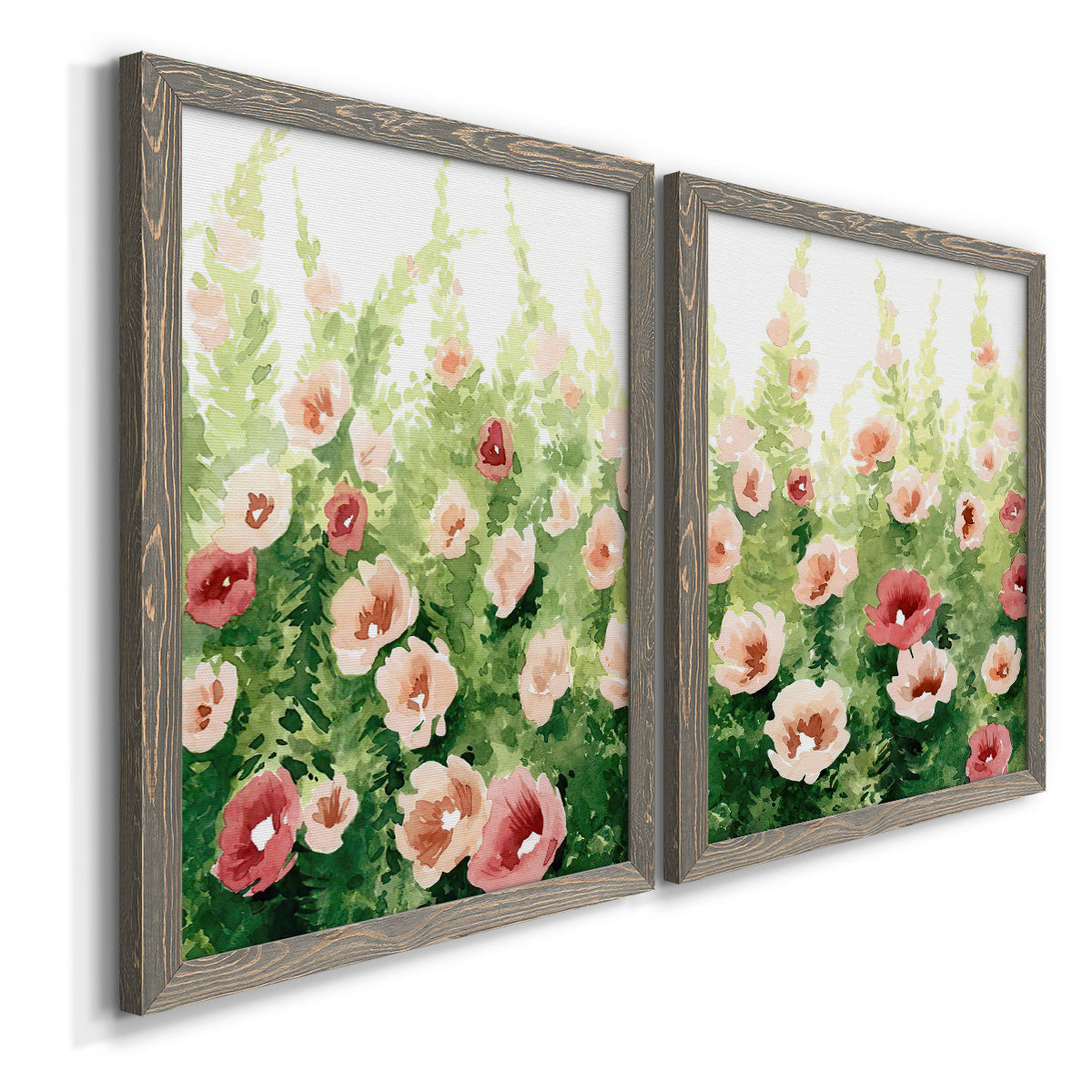 Angled view of a set of two gray barnwood framed canvas prints featuring two luminous impressionistic floral paintings featuring a field of pink coral and white flowers.