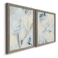 Angled view of a set of two gray barnwood framed canvas prints featuring two airy gestural abstracts featuring pale blue cream and charcoal marks drifting across white.