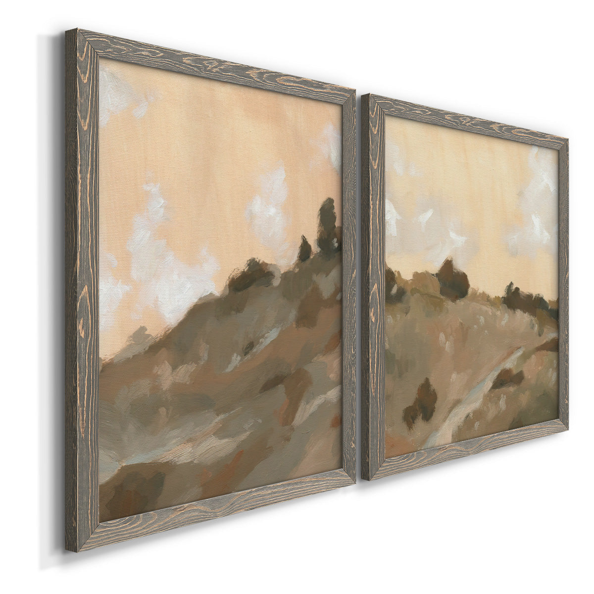 Angled view of a set of two gray barnwood framed canvas prints featuring two minimalist watercolor landscapes featuring misty brown hills and winding mountain paths.