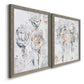 Angled view of a set of two gray barnwood framed canvas prints featuring two expressive floral abstracts featuring loosely suggested flowers and stems in pale gray and peach.