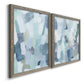 Angled view of a set of two gray barnwood framed canvas prints featuring two cool-toned geometric abstracts featuring fragmented pale blue green gray and white brush blocks.