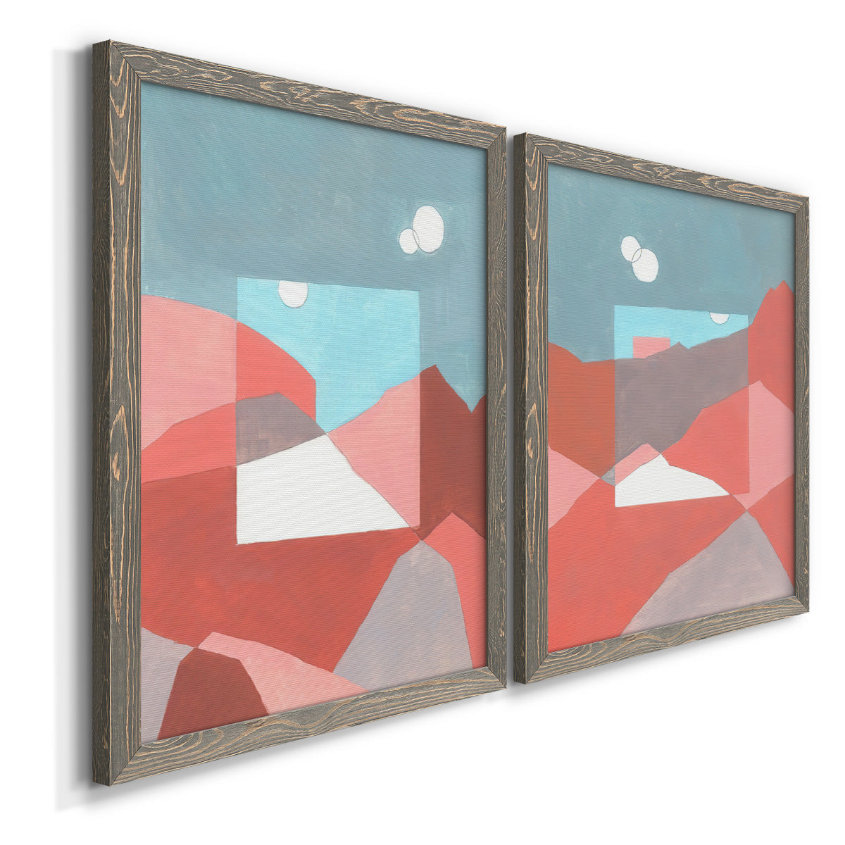 Angled view of a set of two gray barnwood framed canvas prints featuring two modern abstract landscapes featuring layered red coral and turquoise desert-like geometry.