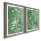 Angled view of a set of two gray barnwood framed canvas prints featuring two rustic minimalist botanical studies featuring delicate wildflower and leafy stems.