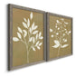 Angled view of a set of two gray barnwood framed canvas prints featuring two minimalist botanical silhouettes with white leafy stems against warm honey gold backgrounds.