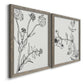 Angled view of a set of two gray barnwood framed canvas prints featuring two minimalist botanical sketches featuring black line drawings of wildflowers and leaves.