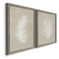 Angled view of a set of two gray barnwood framed canvas prints featuring two minimalist tropical botanical prints featuring white palm frond silhouettes.