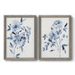 Set of two gray barnwood framed canvas prints featuring two expressive watercolor botanical paintings featuring loose blue flowers and leafy branches.
