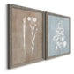 Angled view of a set of two gray barnwood framed canvas prints featuring two rustic minimalist botanical prints featuring white botanical silhouettes on softly weathered neutral backgrounds.