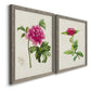 Angled view of a set of two gray barnwood framed canvas prints featuring two vintage botanical plate illustrations featuring pink flowering plant specimens.