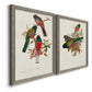 Angled view of a set of two gray barnwood framed canvas prints featuring two vintage ornithological illustrations featuring colorful tropical birds perched on leafy branches.