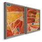 Angled view of a set of two gray barnwood framed canvas prints featuring two warm geometric abstracts featuring faceted rust orange and coral geometric fields.