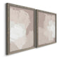 Angled view of a set of two gray barnwood framed canvas prints featuring two neutral minimalist abstracts featuring soft taupe blush and white paint blocks.