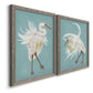 Angled view of a set of two gray barnwood framed canvas prints featuring two decorative bird illustrations featuring white herons displaying long windswept feathers.