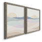 Angled view of a set of two gray barnwood framed canvas prints featuring two minimalist abstract landscapes featuring layered pastel waves beneath a pale setting sun.