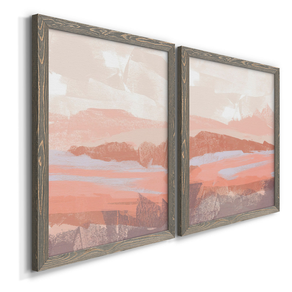 Angled view of a set of two gray barnwood framed canvas prints featuring two modern abstract landscapes featuring layered blush terracotta and blue desert horizons.
