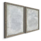 Angled view of a set of two gray barnwood framed canvas prints featuring two quiet textural abstracts featuring layered white and silver-gray painted surfaces.