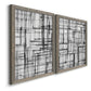 Angled view of a set of two gray barnwood framed canvas prints featuring two monochrome geometric abstracts featuring layered black linear grids.