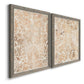 Angled view of a set of two gray barnwood framed canvas prints featuring two vintage decorative prints featuring ornate cream floral damask patterns.