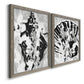Angled view of a set of two gray barnwood framed canvas prints featuring two dramatic monochrome abstracts featuring black and gray inkblot bursts.