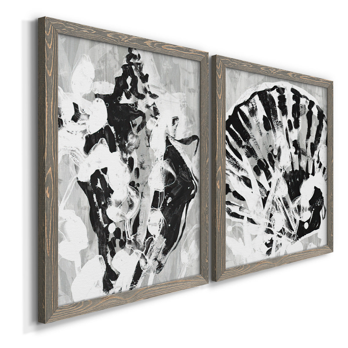 Angled view of a set of two gray barnwood framed canvas prints featuring two dramatic monochrome abstracts featuring black and gray inkblot bursts.