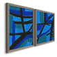 Angled view of a set of two gray barnwood framed canvas prints featuring two bold geometric abstracts featuring intersecting black bars over vivid blue fields.