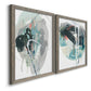Angled view of a set of two gray barnwood framed canvas prints featuring two bold gestural abstracts featuring large black gray and teal circular gestures.