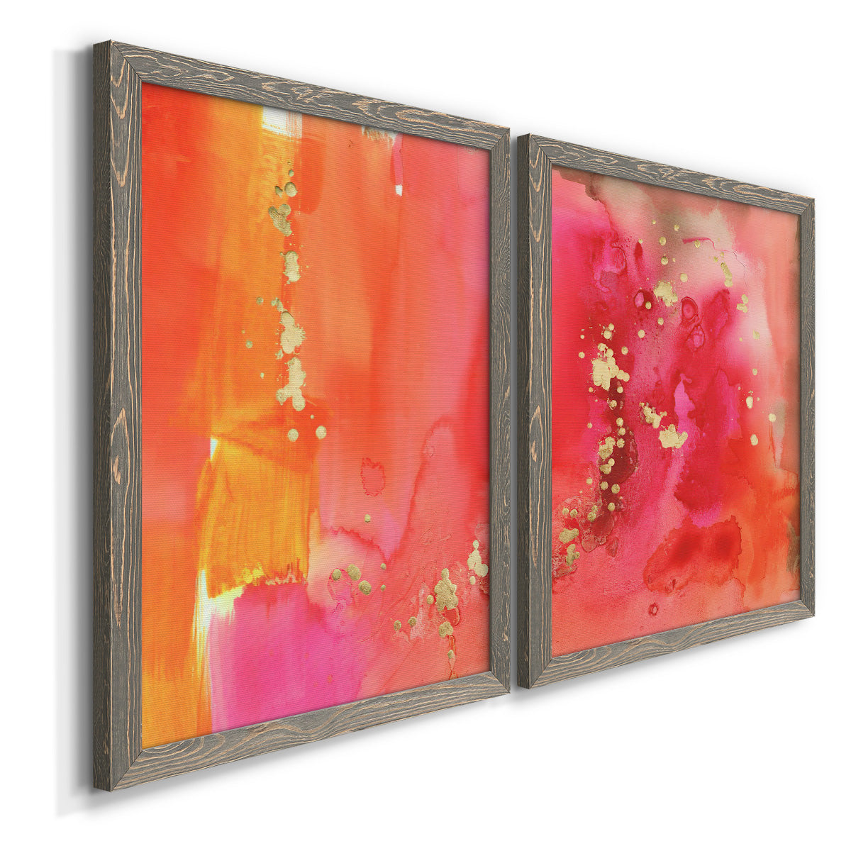 Angled view of a set of two gray barnwood framed canvas prints featuring two glamorous fluid abstracts featuring luminous coral orange and pink color fields with gold flecks.