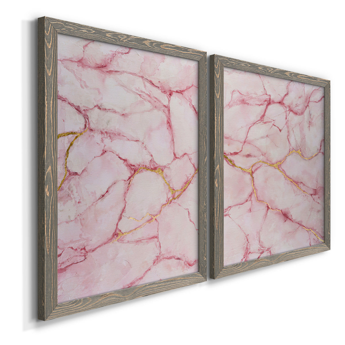 Angled view of a set of two gray barnwood framed canvas prints featuring two soft stone-inspired abstracts featuring pink marble veining with fine gold lines.