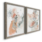 Angled view of a set of two gray barnwood framed canvas prints featuring two abstract watercolor botanicals featuring loose blush gray and coral floral gestures.