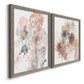 Angled view of a set of two gray barnwood framed canvas prints featuring two abstract watercolor botanicals featuring loose blush gray and coral floral gestures.