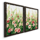 Angled view of a set of two black barnwood framed canvas prints featuring two luminous impressionistic floral paintings featuring a field of pink coral and white flowers.